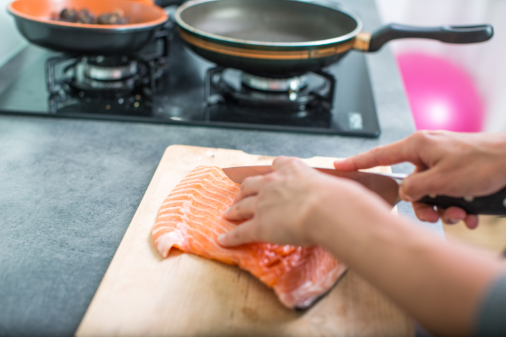 woman cooking salmon