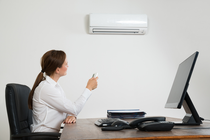 woman sitting by air conditioner