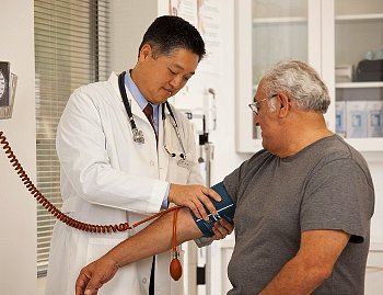 A doctor checks a man's blood pressure