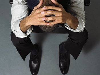 Depressed business man with hands on head.