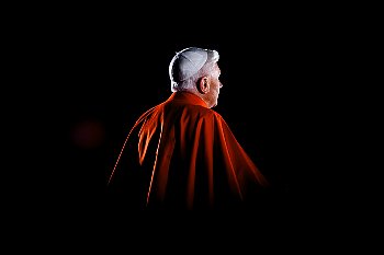 Pope Benedict XVI from the back surrounded by darkness