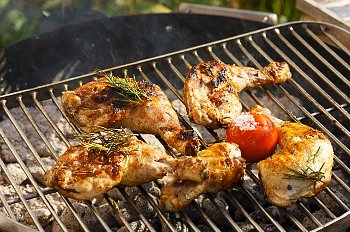 pieces of chicken cooking on a grill