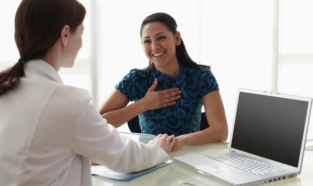 A woman talking to a doctor in her office