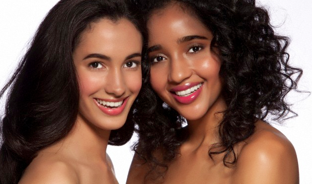 Two women with bare shoulders smiling