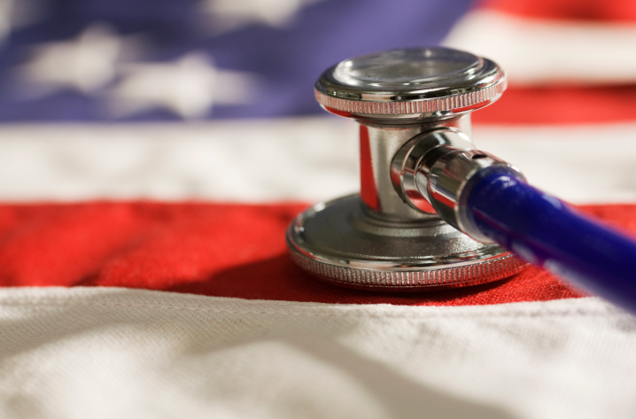 A blue and silver stethoscope sitting on top of an American flag