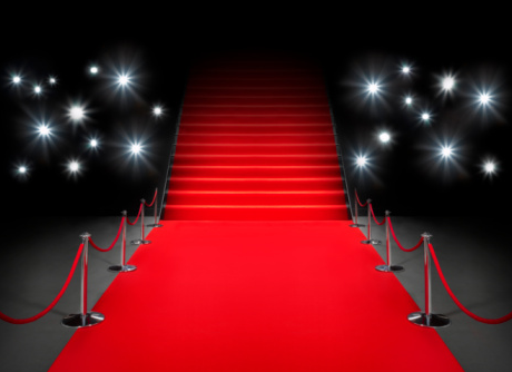 A red carpet with flashing lights in the background