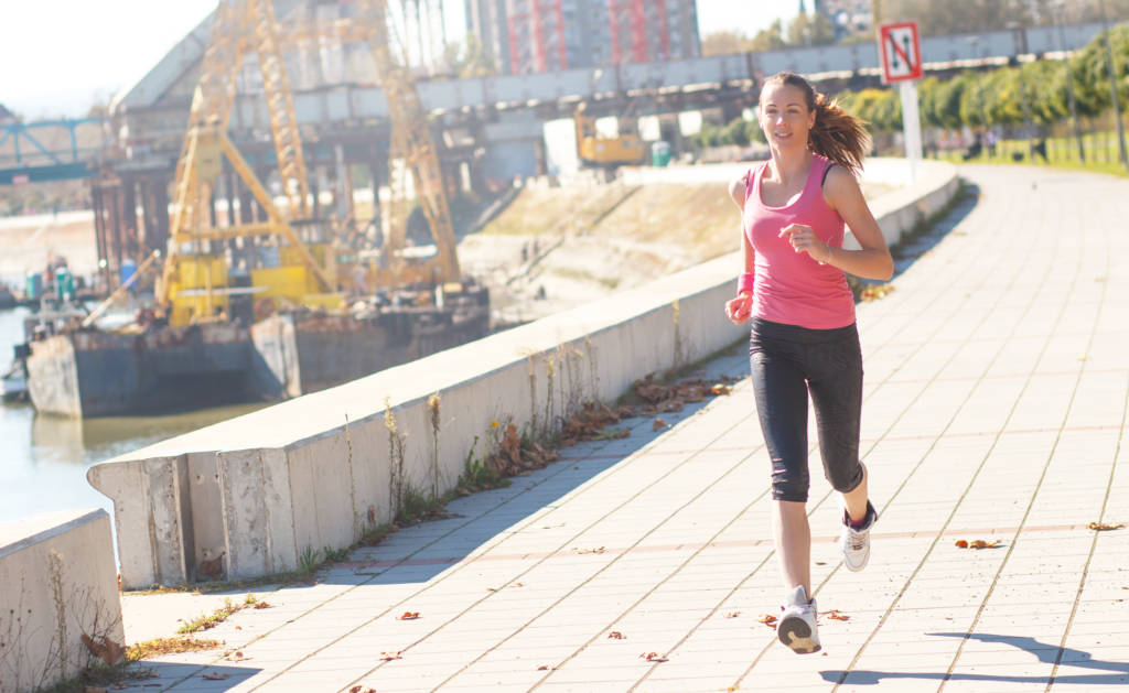 young woman running, woman jogging, woman in capris running