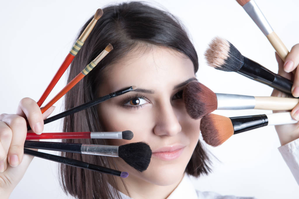 woman with beauty brushes, hispanic woman, face brushes, short-haired woman applying makeup