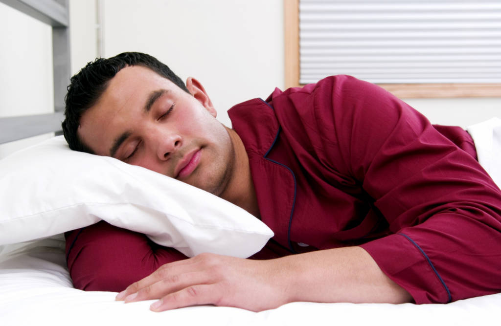 hispanic man sleeping in bed