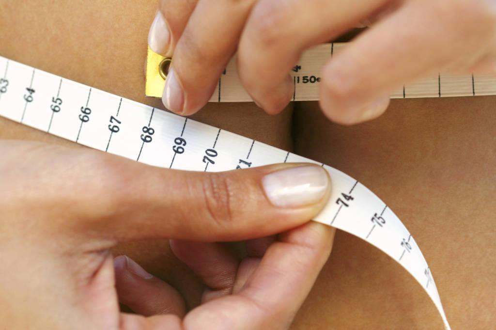 Woman measuring waistline, weightloss