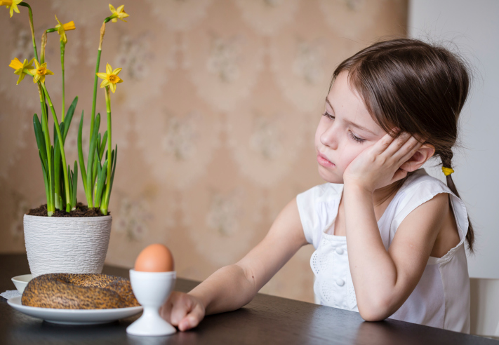 girl refusing to eat bagel and eggs