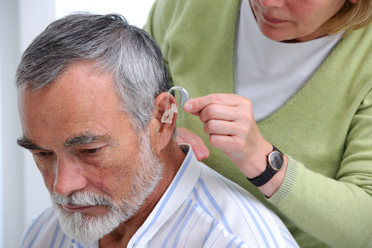 doctor inserting hearing aid
