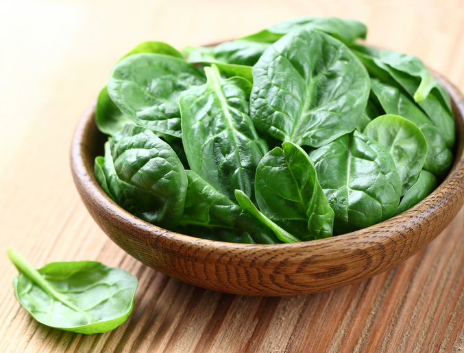 Baby spinach on a wooden background