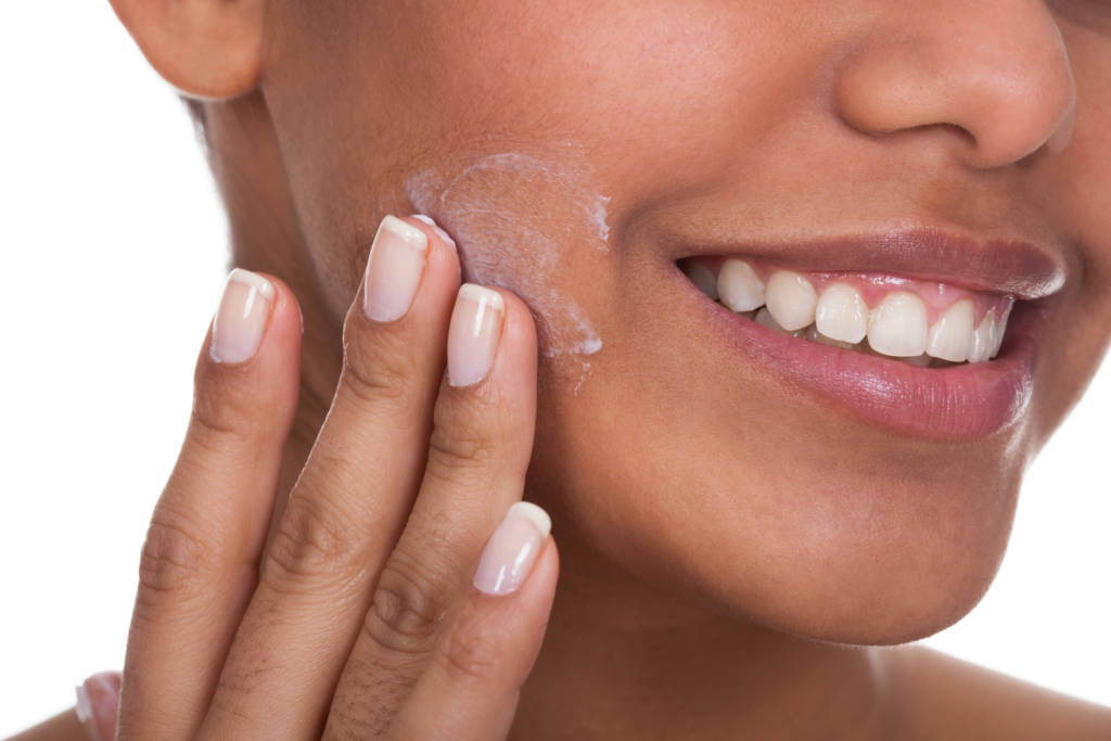 woman applying lotion on face