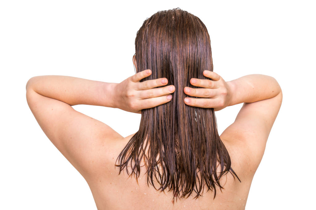 woman applying oil to hair
