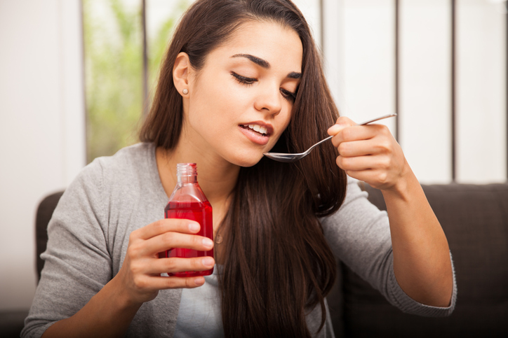 woman drinking cough syrup