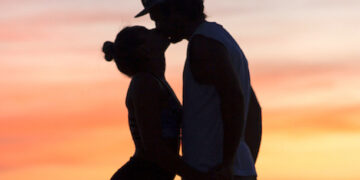 Silhouette of man and woman kissing during sunset